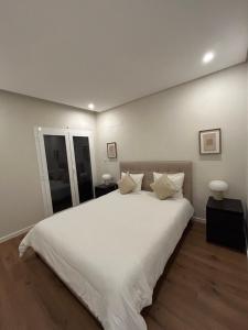 a bedroom with a large bed with white sheets and pillows at The Place to Stay ! in Póvoa de Santa Iria +3 photos