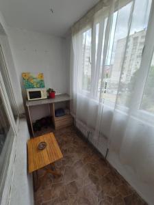 a small room with a table and a window at Mladost stay apartment in Sofia +3 photos