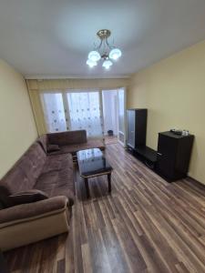 a living room with a couch and a television at Mladost stay apartment in Sofia