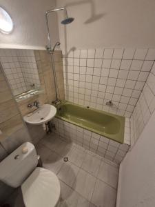 a bathroom with a toilet and a sink and a tub at Mladost stay apartment in Sofia