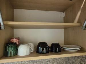 a shelf with pots and pans and plates on it at Mladost stay apartment in Sofia
