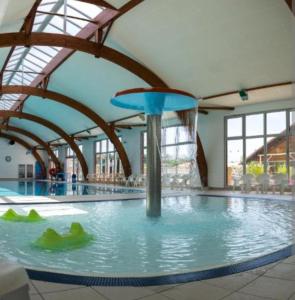 a large swimming pool with a fountain in a building at WOW Holidays - 8 Person, 5 Star Mobile-Home with Terrace in Gastes