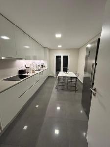 a large white kitchen with a table and chairs at The Place to Stay ! in Póvoa de Santa Iria