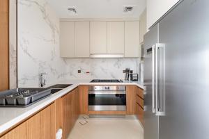 a kitchen with white cabinets and a stainless steel refrigerator at Address Residence Dubai Opera 25 by Luxstay Holiday Homes in Dubai
