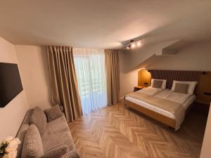 a hotel room with a bed and a couch at Pensiunea AN de AN Remeti in Remeţi +40 photos