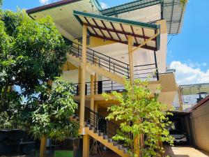 a building with stairs and trees in front of it at Yala Hotel Grand View in Tissamaharama