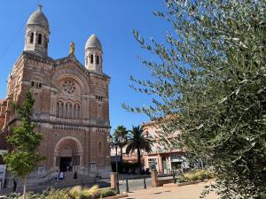 une église avec deux tours sur le côté dans l'établissement Studio Terrasse Vue Mer Saint-Raphaël - Plages, Ville et Gare à Pied, à Saint-Raphaël