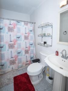 a bathroom with a white toilet and a sink at The Residence Portmore Apartments in Portmore