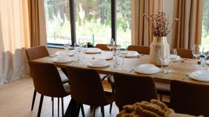 a dining room table with chairs and a vase with flowers at Vikendica Marija Blidinje in Blidinje