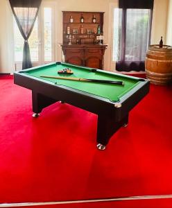 a pool table in a room with a red floor at "Instant Zen" Chambre double - 15 min Merignac airport et Bordeaux in Saint-Médard-en-Jalles