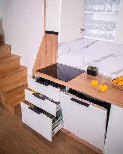 a kitchen with white drawers and a counter with wine glasses at Vikendica Marija Blidinje in Blidinje +24 photos