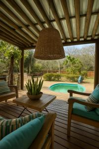 a patio with a table and chairs and a pool at Villa Bajaú in Serra do Cipo