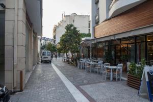 an empty street with tables and chairs in a city at Argo Luxury House in Volos