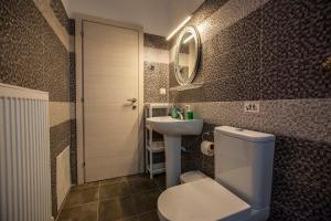 a bathroom with a toilet and a sink and a mirror at Argo Luxury House in Volos +35 photos