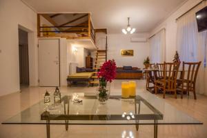 a living room with a vase of flowers on a glass table at Argo Luxury House in Volos