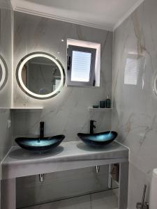 une salle de bain avec deux lavabos bleus et un miroir dans l'établissement Villa Aurora amazing seaview to Lefkada - Meganisi, à Plagiá 55 autres photos