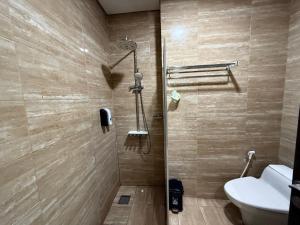 a bathroom with a toilet and a shower at Hotel Grand Kerinci Sungai Penuh - Syariah in Sungaipenuh