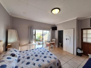 a bedroom with a bed and a table and a window at Mooisig oornagverblyf in Mossel Bay