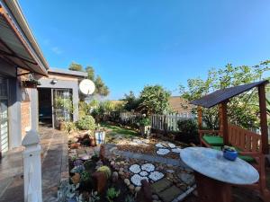 a backyard with a table and a fence at Mooisig oornagverblyf in Mossel Bay