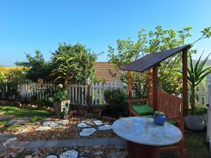 a garden with a table and a gazebo at Mooisig oornagverblyf in Mossel Bay