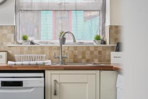 eine Küche mit Spüle und Fenster in der Unterkunft The cottage near the castle in Conisbrough + 96 Fotos