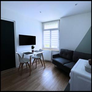een woonkamer met een bank en een tafel bij SQ'Appart x in Saint-Quentin