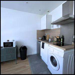 een keuken met een wasmachine en een magnetron bij SQ'Appart x in Saint-Quentin
