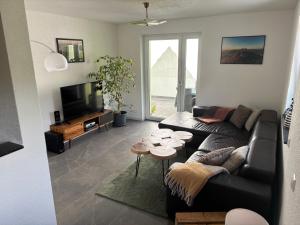 a living room with a couch and a tv at Pfalzliebe in Rinnthal