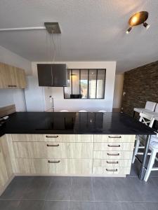 una cucina con piano di lavoro nero in una camera di Garden space - T4 - Airport - Garden - Tram a Blagnac