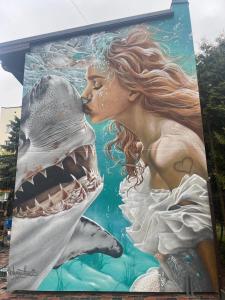 a mural of a mermaid and a shark on a building at Shark in Liepāja