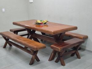 a wooden table and bench with a wooden table and sidx sidx sidx at Praia Peito de Moça in Luis Correia