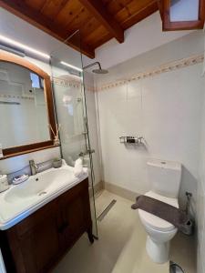 a bathroom with a sink and a toilet and a mirror at Elia Concept Apartments in Ano Syros