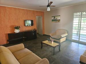 a living room with two couches and a tv at Chácara Paraíso Country House Events in Bauru
