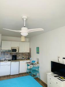 a kitchen with white cabinets and a ceiling fan at Marina Beach-Apartamentos Tahiche in Costa Teguise