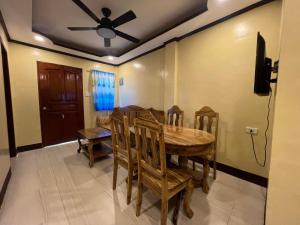 a dining room with a table and chairs and a ceiling fan at EAVs Homestay in Mahinog
