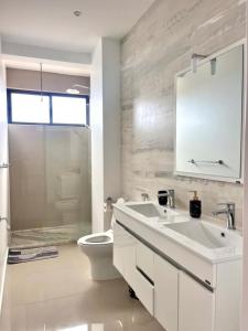 a bathroom with a sink and a toilet and a mirror at Casa BB&Djassi - Apartment T2 in Ponta do Sol +13 photos