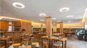 格拉玛多Locar in Gramado, Quarto em hotel, Natal-Luz, Quarto Bairro Planalto do Lago N, Aconchegante, frente para Lago N的一间房间里有木桌椅的餐厅