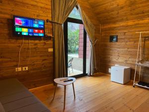 a living room with a tv and a table and a chair at Dalmace Villas in Koman