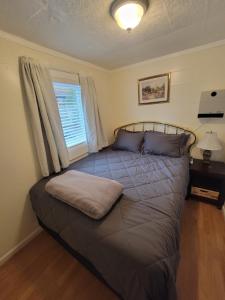 a large bed in a bedroom with a window at Downtown Juneau Gold Street Apartments in Juneau