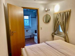 a bedroom with two beds and a bathroom with a toilet at Hof zum alten Birnbaum in Friedland +19 photos