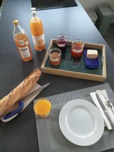 a tray of food with a plate and a bottle of orange juice at La Naute in Saint-Paulien