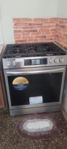 a stove top oven sitting next to a brick wall at Casa verde in Tunapuna