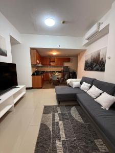 a living room with a couch and a kitchen at Executive Suites Bellagio Golf View Residences in Manila