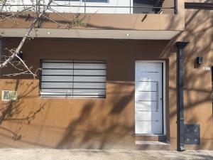 a building with two windows and a door at Hospedaje Umma 3-Ezeiza in Ezeiza