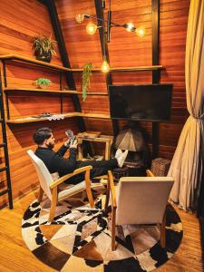 a man sitting in a chair in front of a tv at Audaz 1 in Água Boa
