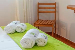 a group of towels on a bed with a chair at Casas do Porto - Azalea and Hortênsia in Mosteiros
