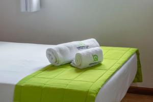 a pile of towels sitting on a bed at Casas do Porto - Azalea and Hortênsia in Mosteiros