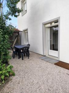 a patio with a table and chairs in front of a building at Appartement calme avec jardin in Saint-Ambreuil +12 photos