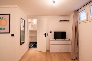 a living room with a television on a white dresser at Studio Place Masséna in Nice