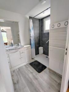a white bathroom with a sink and a shower at Appartement calme avec jardin in Saint-Ambreuil